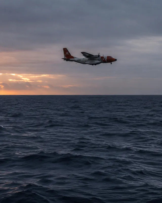 Avión de búsqueda y rescate sobrevolando el océano Atlántico al amanecer, aguas oscuras y agitadas