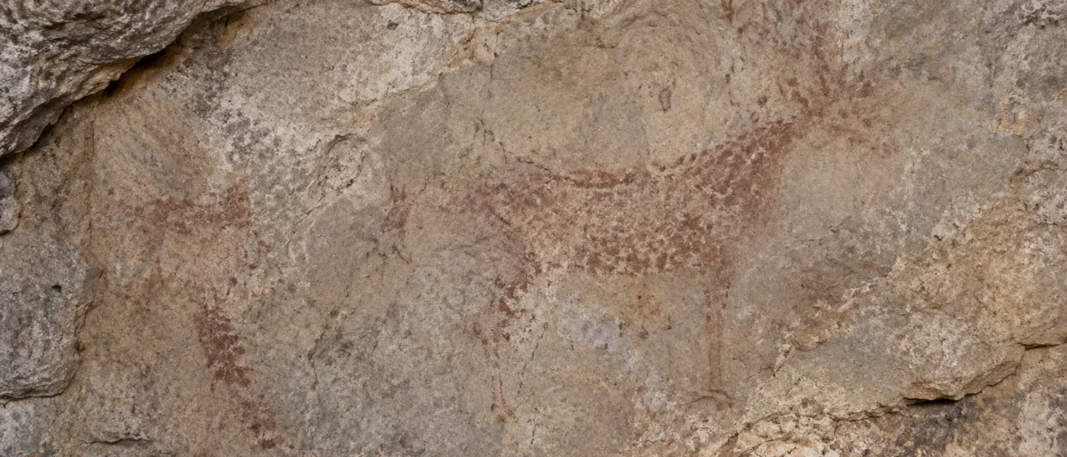 Fotografía editorial de una pared de roca con pigmentos de arte rupestre realzados mediante procesamiento digital de colores falsos